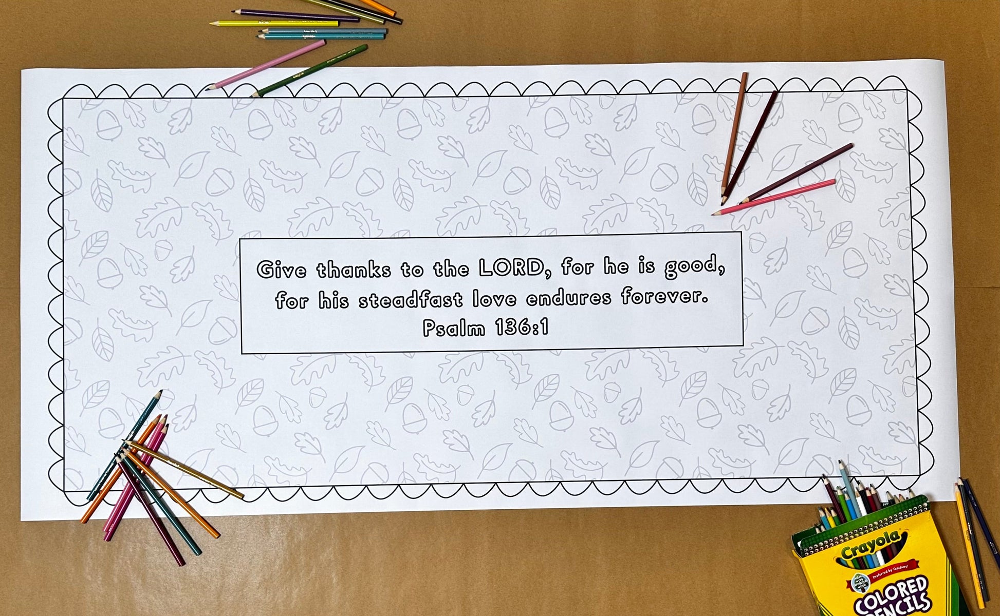 Coloring page with a Bible verse surrounded by colored pencils on a wooden surface. Fall coloring page. Thankfulness and gratitude banner.